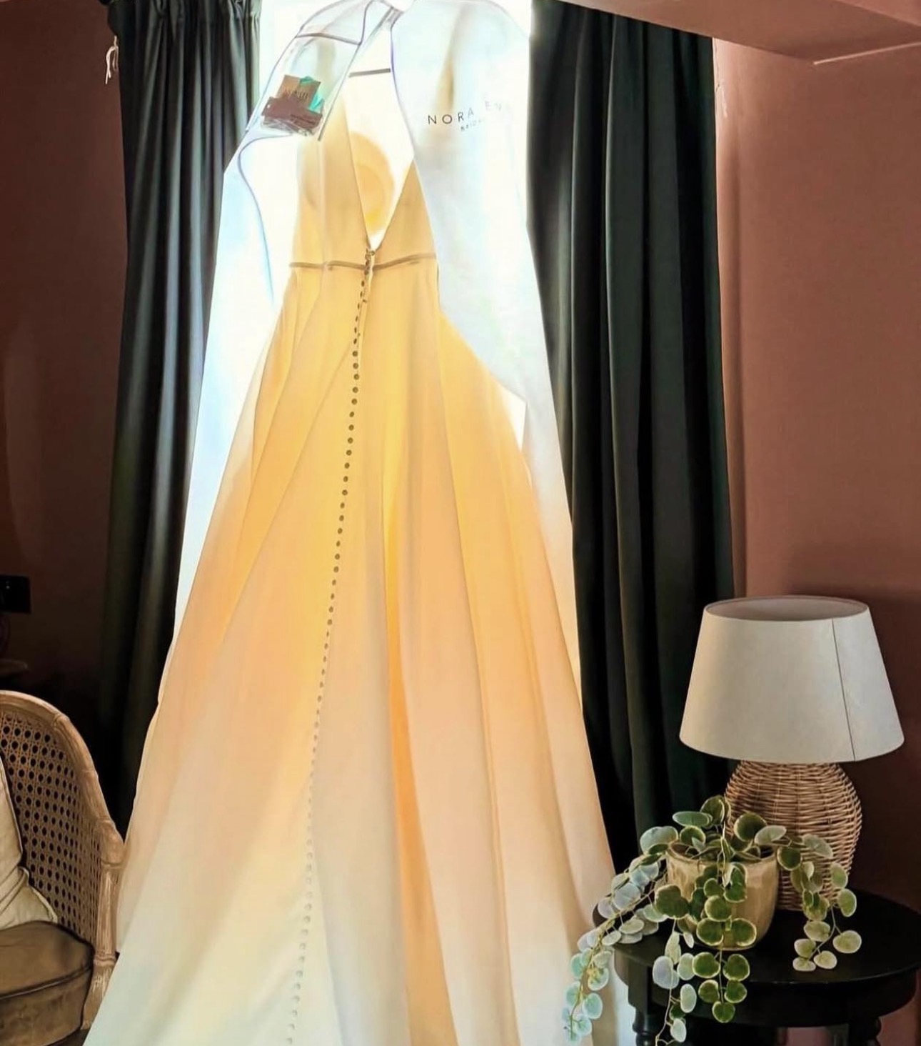 Wedding dress hanging by a window in a Knutsford boutique hotel room