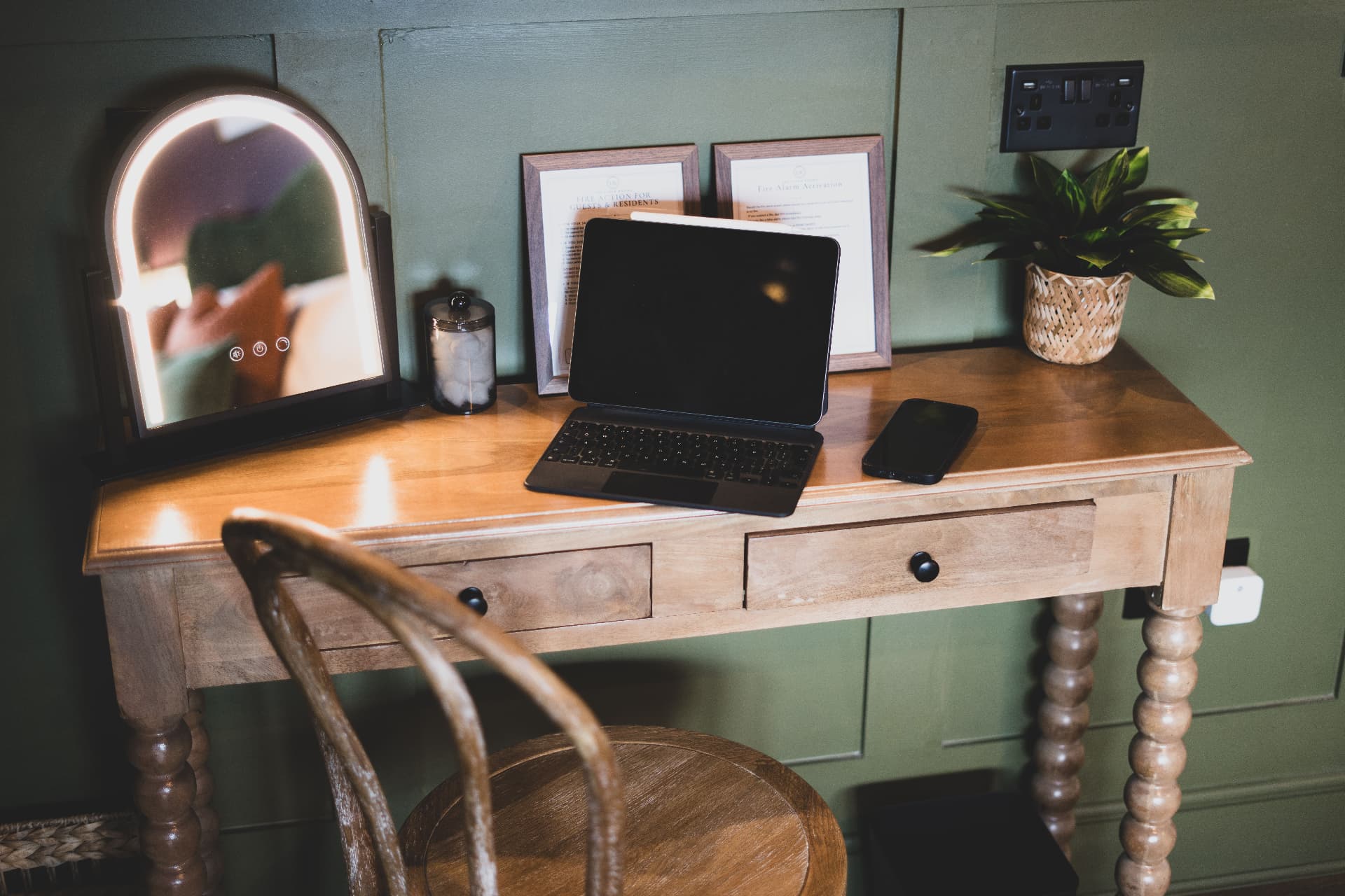Desk with tablet keyboard, chair and lit mirror in a Knutsford business stay room